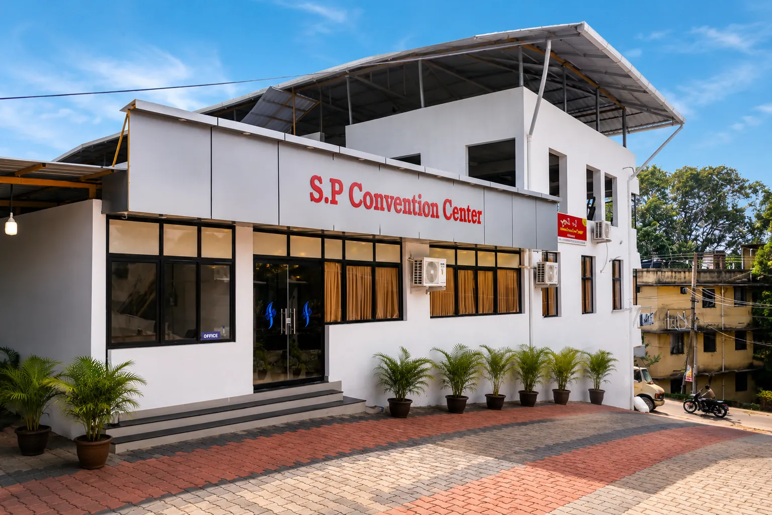 Front entrance of S P Convention Center in Naruvamoodu, with the S.P Convention Center signage above the office and the paved forecourt