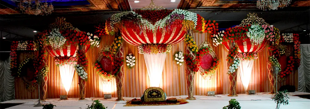 Red and white floral mandap set for a wedding at S P Convention Center