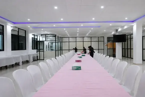 Long banquet dining table with white chair covers set for a large function