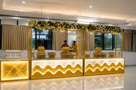 Gold-lit catering counters with a floral canopy set for a wedding banquet